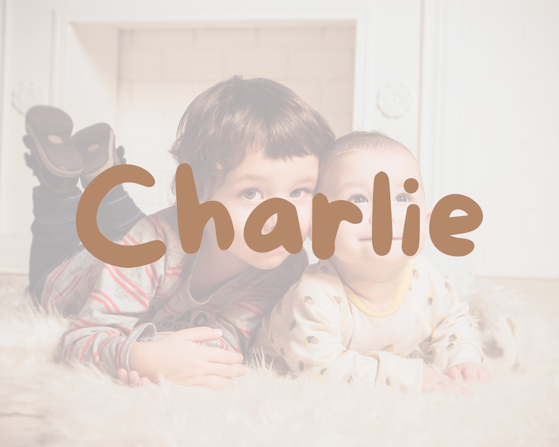 Deux jeunes enfants couchés côte à côte sur un tapis moelleux, avec le prénom Charlie écrit par-dessus l’image.