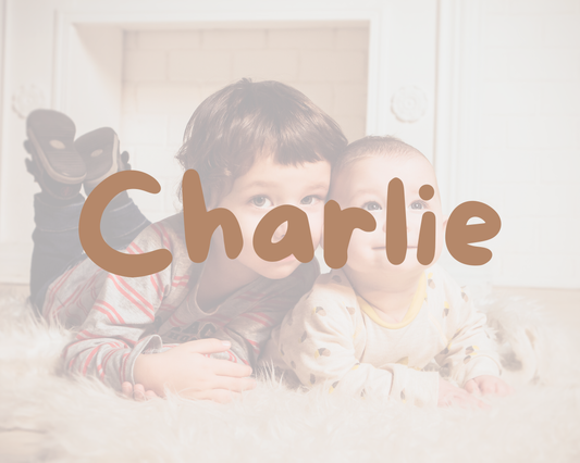 Deux jeunes enfants couchés côte à côte sur un tapis moelleux, avec le prénom Charlie écrit par-dessus l’image.