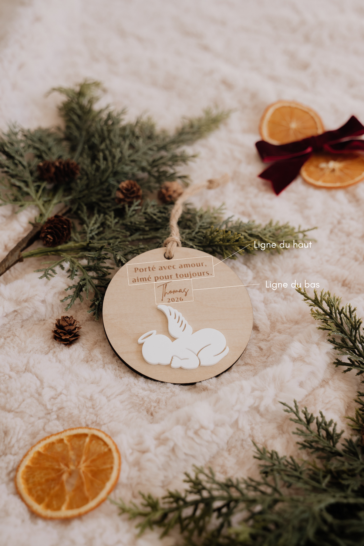 Boule de Noël personnalisée - Superposée : bébé ange blanc en relief et repères des deux zones de texte gravé.