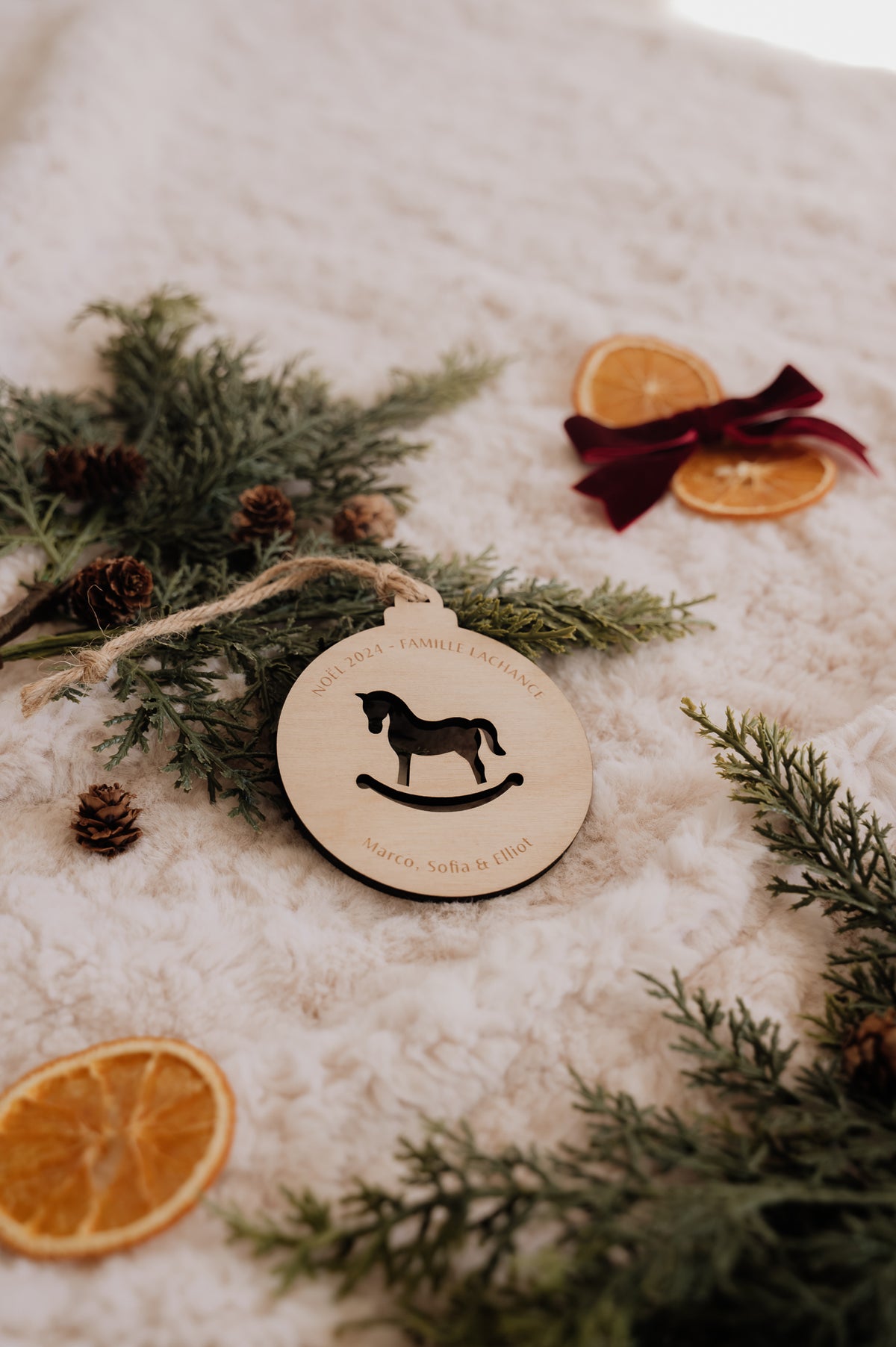 Boule de Noël personnalisée - Découpe : cheval à bascule ajouré, avec texte gravé et cordon de jute.