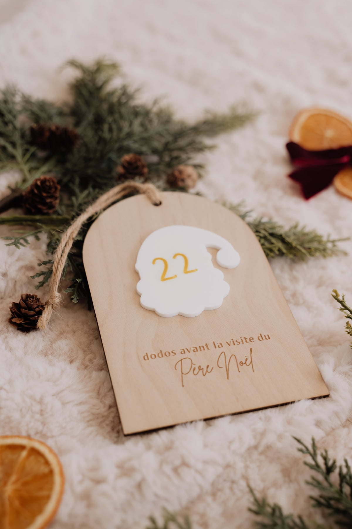Dodos avant Noël : décompte en bois avec le nombre 22 sur le Père Noël blanc, posé près de sapin et de pommes de pin.