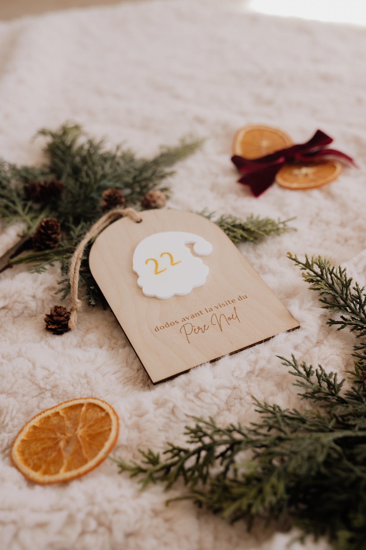 Dodos avant Noël : vue d’ensemble du décompte affichant 22, entouré de sapin, d’oranges séchées et d’un ruban bordeaux.