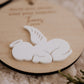 Boule de Noël personnalisée - Superposée : détail du bébé ange blanc couché, montrant le relief sur le disque en bois.