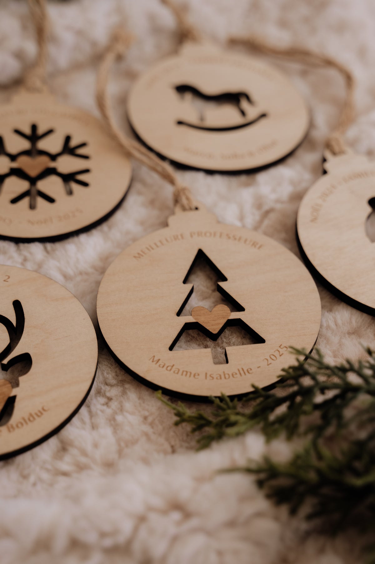 Boule de Noël personnalisée - Découpe : gros plan du sapin avec cœur et texte « Madame Isabelle - 2025 ».