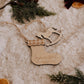 Ornement personnalisé - Formes : bas de Noël et cheval à bascule en bois sur une couverture crème, près de sapin.
