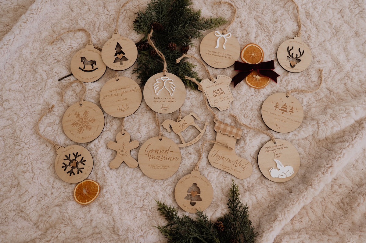 Ornement personnalisé - Cache couche : vue d’ensemble du modèle parmi des ornements de Noël sur une couverture crème.